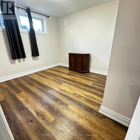 A room with wooden flooring and a wooden cabinet.