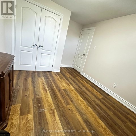 A room with wooden flooring and white walls.