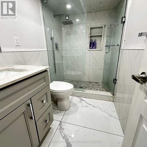 A white toilet sits in a marble bathroom.
