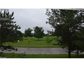 A tree in a grassy area with a sign that says Nu-Vista Pinnacle Realty Brokerage Inc.