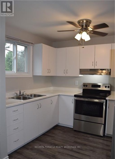 A kitchen with white cabinets and a stainless steel oven.