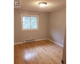 A room with a window and wooden flooring.