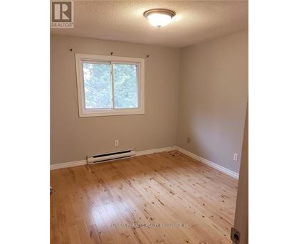 A room with a window and wooden flooring.