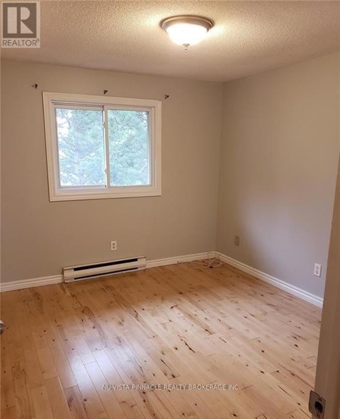 A room with a window and wooden flooring.