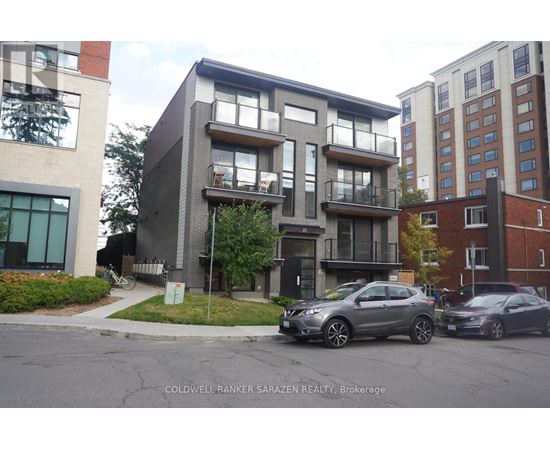 A modern apartment building with cars parked in front.