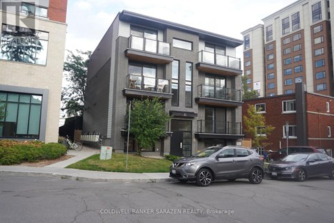 A modern apartment building with cars parked in front.