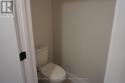 A small white toilet in a small bathroom.