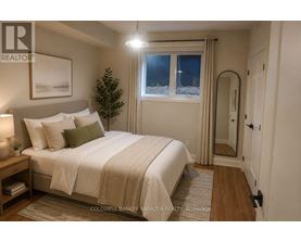 A well-lit bedroom with a large bed and a small tree.