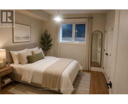 A well-lit bedroom with a large bed and a small tree.