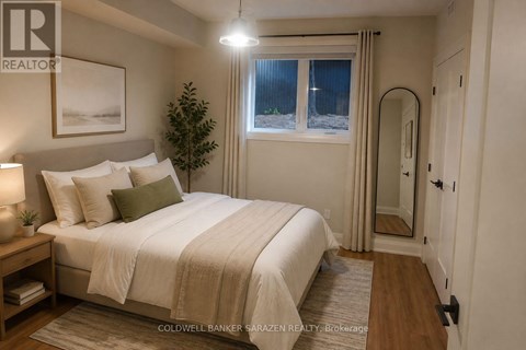 A well-lit bedroom with a large bed and a small tree.