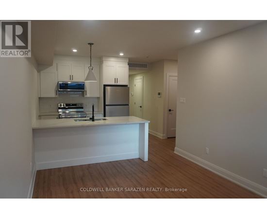 A kitchen with a stainless steel refrigerator and a stove top oven.