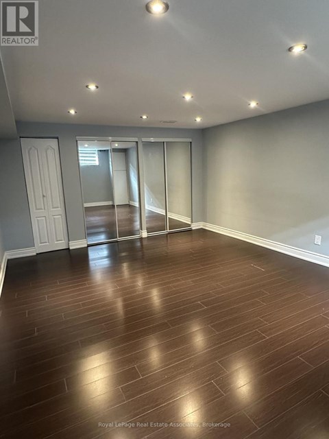 A spacious room with wooden flooring and sliding glass doors.