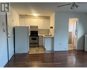 A kitchen with a refrigerator, oven, and sink.