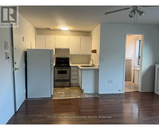 A kitchen with a refrigerator, oven, and sink.
