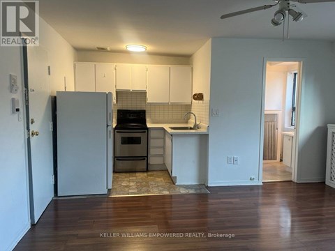 A kitchen with a refrigerator, oven, and sink.