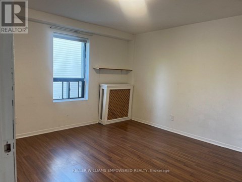 A room with a window and a fireplace with a wooden screen.