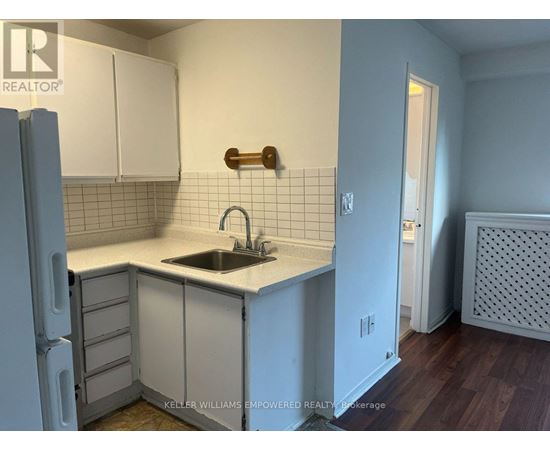 A kitchen with white cabinets and a white counter top.