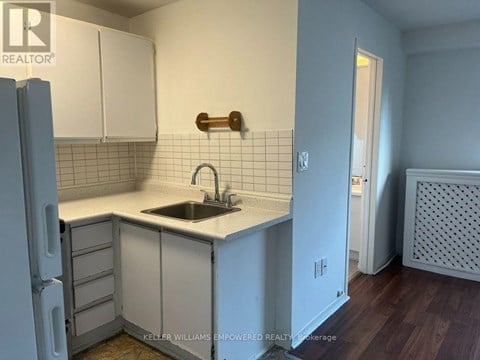 A kitchen with white cabinets and a white counter top.