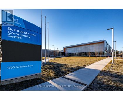 A blue and white sign for the Burnhamthorpe Community Centre stands in front of a modern building.