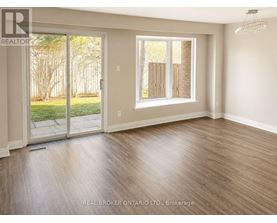 A room with a sliding glass door leading to a backyard.