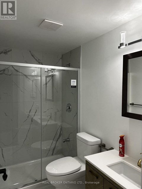 A bathroom with a toilet, sink, and shower.