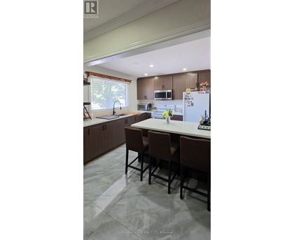 A kitchen with brown chairs and a white fridge.
