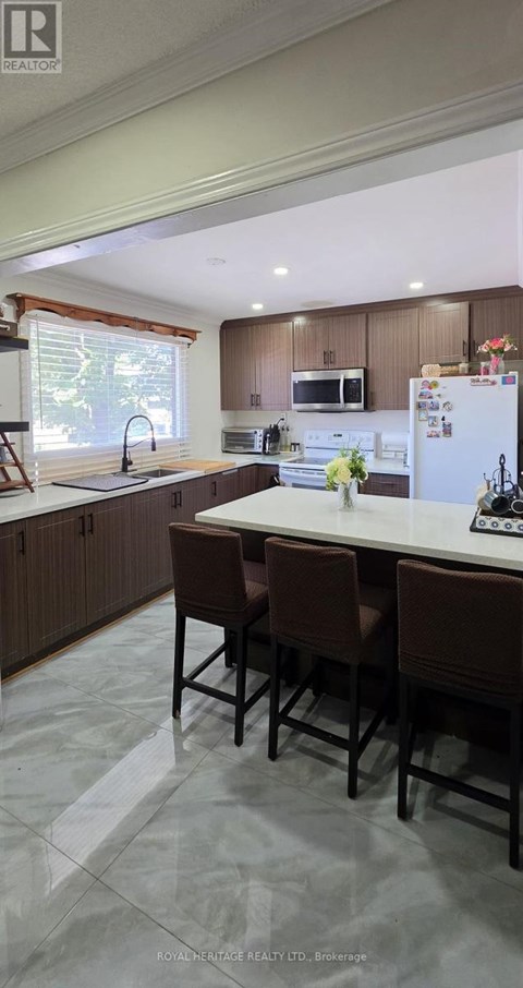 A kitchen with brown chairs and a white fridge.