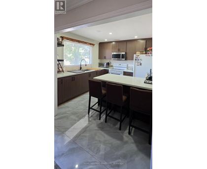 A kitchen with brown chairs and a white fridge.