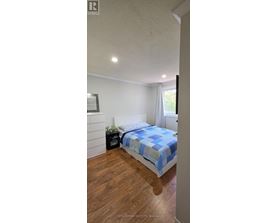 A bedroom with a bed and a nightstand.