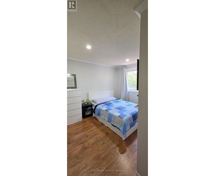 A bedroom with a bed and a nightstand.