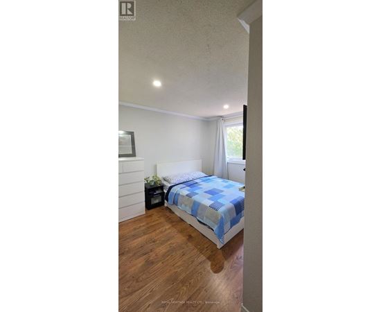 A bedroom with a bed and a nightstand.