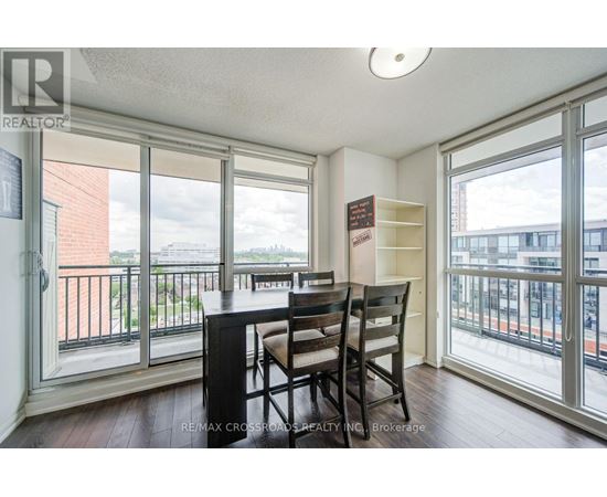 A dining room with a table and chairs and a view of the city.