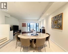 A dining room with a table set for four and a television.