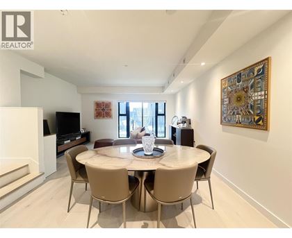 A dining room with a table set for four and a television.