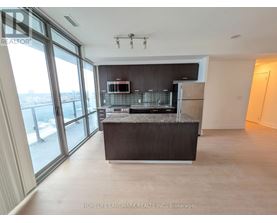 A spacious kitchen with a granite countertop and stainless steel appliances.