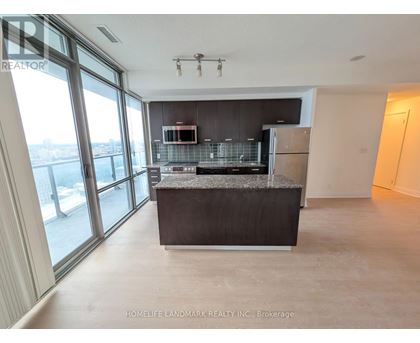 A spacious kitchen with a granite countertop and stainless steel appliances.