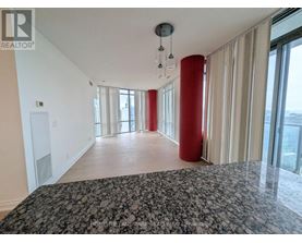 A spacious room with a large bed and a view of the city.