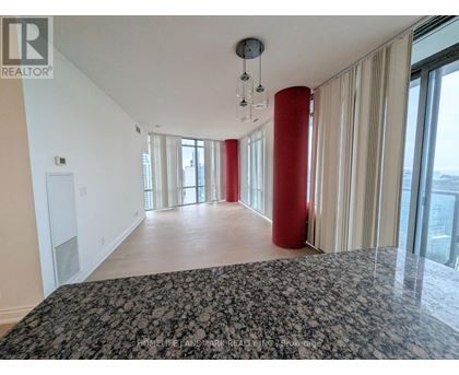 A spacious room with a large bed and a view of the city.