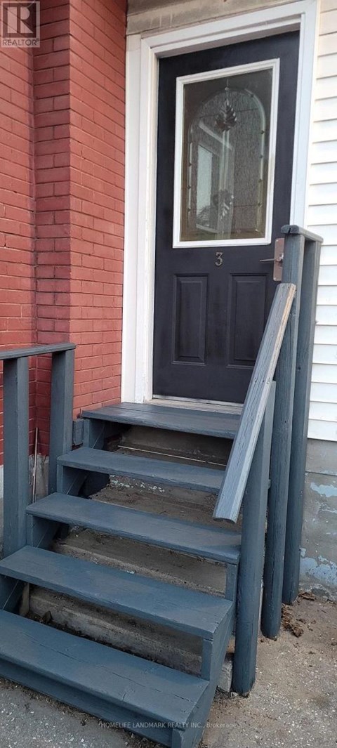 A set of stairs leading to a door with a glass window.