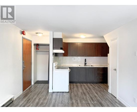 A kitchen with a white dishwasher and wooden cabinets.