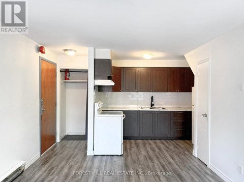 A kitchen with a white dishwasher and wooden cabinets.