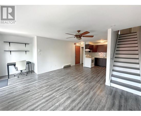 A spacious room with a staircase leading to the upper floor.