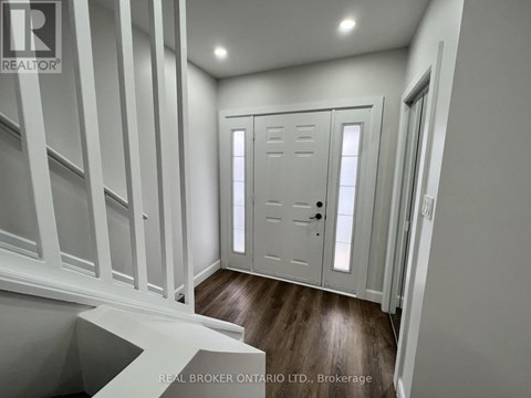 A white door with a black handle is in a room with white walls.