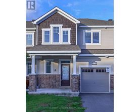 A house with a brown door and a garage door numbered 2535.