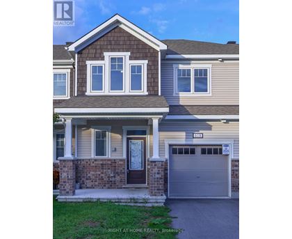 A house with a brown door and a garage door numbered 2535.