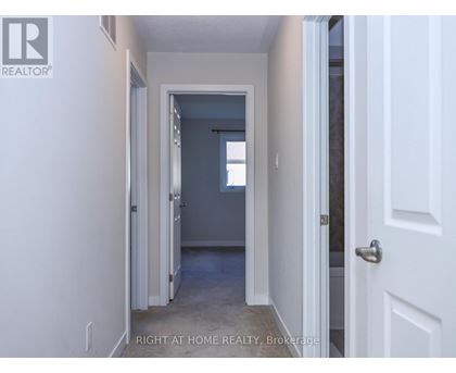 A hallway with a door on the right and a window in the distance.