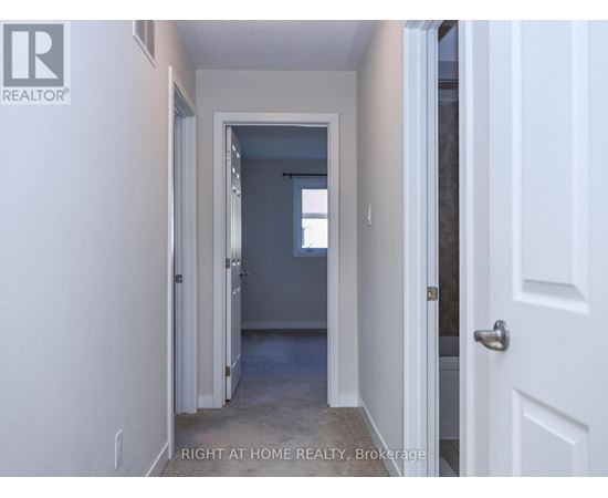 A hallway with a door on the right and a window in the distance.