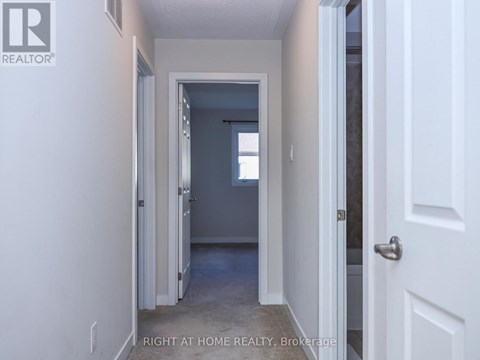 A hallway with a door on the right and a window in the distance.