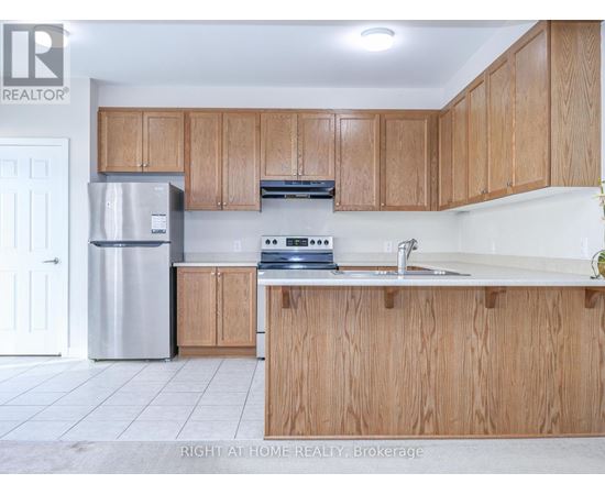 A kitchen with wooden cabinets and a stainless steel refrigerator.