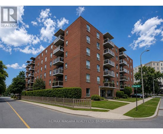 A large red brick apartment building with balconies on the upper floors.